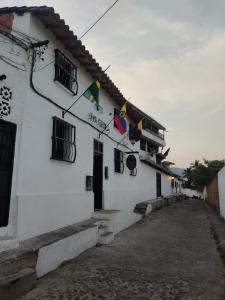 un edificio blanco con banderas a un lado en Hotel Gran Girones, en Girón
