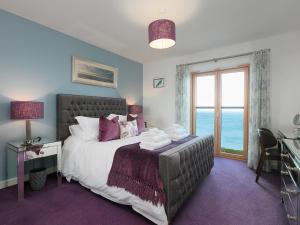 um quarto com uma cama e uma janela com o oceano em Elanora em Carbis Bay