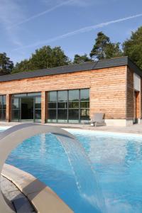 a swimming pool in front of a building at Résidence Vacancéole - Le Domaine des Monédières in Meyrignac-lʼÉglise