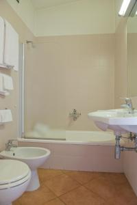 a bathroom with a toilet and a sink and a tub at Autohotel Ravenna in Ravenna