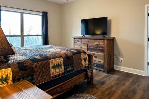 Schlafzimmer mit einem Bett und einer Kommode mit einem TV in der Unterkunft Shady Pines in Gatlinburg