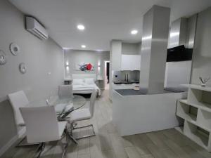 Loft Ciudad Jardín N°2 في قرطبة: مطبخ مع طاولة زجاجية وكراسي بيضاء