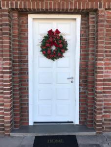 uma porta branca com uma coroa de Natal em St. Virginia’s em Gramado