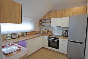 - une cuisine avec des appareils blancs et une table en bois dans l'établissement L'escapade, à Limoges
