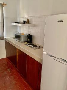 a kitchen with a white refrigerator and a microwave at Creta Hotel & Suites in Mazatlán