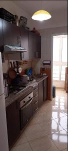 a kitchen with stainless steel appliances and a large window at Appartement de luxe à el jadida in El Jadida