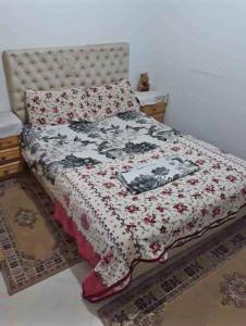 a bedroom with a bed with a floral bedspread at Appartement de luxe à el jadida in El Jadida