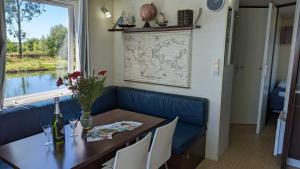 uma sala de jantar com uma mesa e um sofá azul em Cottage flottant jacuzzi privé en option gamme supérieure em Saint-Jean-de-Losne