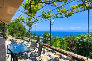 een patio met een tafel en stoelen en de oceaan bij Antigoni Villas in Longós