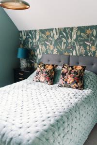 a bedroom with a white bed with a floral wallpaper at Chapel House Estate in Kent