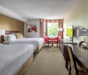 a hotel room with two beds and a desk at Hôtel WelcomInns in Boucherville +19 photos