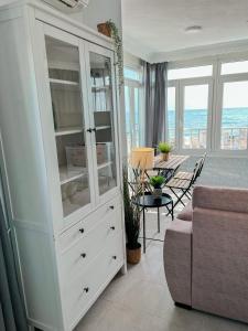 a living room with a large white cabinet and a table at Beautiful sea views apartment Pool & Beach in Torremolinos