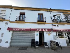 a building with chairs in front of a store at Casa Kini in Cazalla de la Sierra