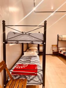 Ce lit superposé se trouve dans un dortoir doté d'une chaise en bois. dans l'établissement Casa Sumaq, à Buenos Aires