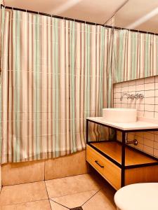 baño con lavabo y cortina de ducha en Casa Sumaq en Buenos Aires
