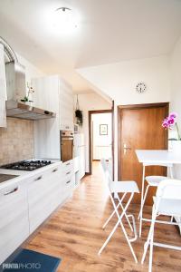- une cuisine avec des placards blancs, une table et des chaises dans l'établissement Valmontone Travel Rooms (casa vacanze), à Valmontone