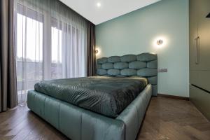 a bedroom with a bed and a large window at Pajūrio Oazė MG13 in Klaipėda