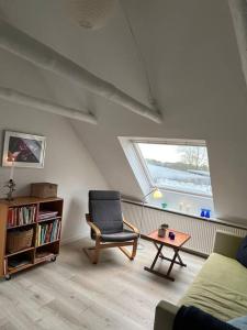 ein Wohnzimmer mit einem Stuhl und einem Tisch in der Unterkunft Skønt hus på landet tæt på Billund in Give