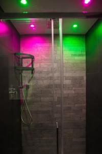 a bathroom with a shower with green and pink lights at Trevi & Pantheon Luxury Rooms in Rome