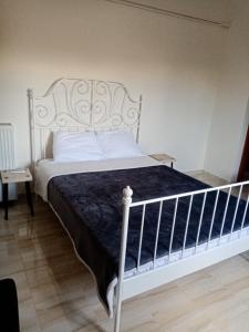a bedroom with a white bed with a blue blanket at Cosy Apartment in relaxed neighbourhood in Amarynthos