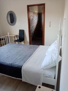 a bedroom with a bed and a chair and a mirror at Cosy Apartment in relaxed neighbourhood in Amarynthos