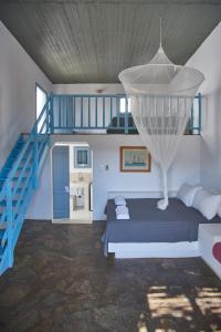 a bedroom with a bed and a blue staircase at Oliaros seaside complex in Agios Georgios