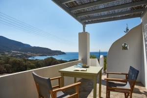 d'une table et de chaises sur un balcon avec vue sur l'océan. dans l'établissement Oliaros seaside complex, à Agios Georgios