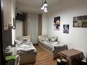 un soggiorno con 2 letti e un tavolo di Leselidze Guest House a Tbilisi City