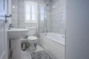 a bathroom with a toilet and a sink and a bath tub at Ty Melyn - 2 Bedroom Cottage - Tenby in Tenby +60 photos