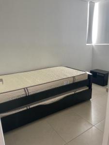a bed sitting on top of a floor in a room at Bonito y cómodo apartamento en el Rodadero. in Gaira