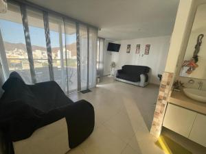 een woonkamer met een bank en een wastafel bij Bonito y cómodo apartamento en el Rodadero. in Gaira