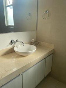 een badkamer met een witte wastafel en een spiegel bij Bonito y cómodo apartamento en el Rodadero. in Gaira