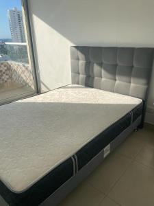 een bed in een kamer naast een raam bij Bonito y cómodo apartamento en el Rodadero. in Gaira