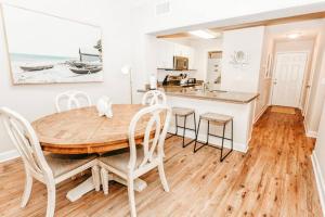 een keuken en eetkamer met een houten tafel en stoelen bij Poolside Condo at Waterside in Mexico Beach