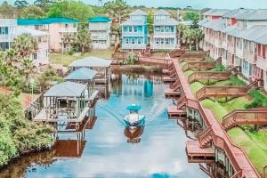 een boot is aangemeerd op een rivier met gebouwen bij Poolside Condo at Waterside in Mexico Beach