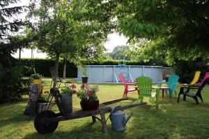 - un jardin avec des chaises colorées et une table fleurie dans l'établissement Gite De La Meronne, à Vindelle