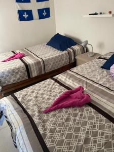 Dos camas en una habitación con toallas rosas. en Casa de tus Sueños Dream Lagoons Veracruz, en Veracruz