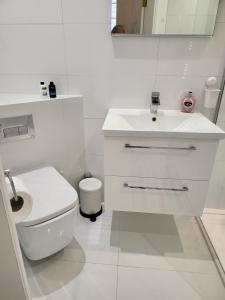 a white bathroom with a toilet and a sink at Langhouse Castle Bed and Breakfast in Inverkip