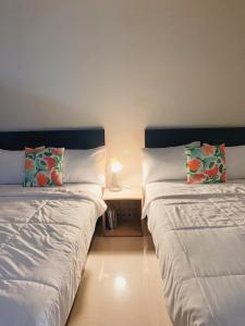 2 Betten nebeneinander in einem Zimmer in der Unterkunft My Own Hotel-like Studio Apartment. Near Unpad! in Cilimus 2