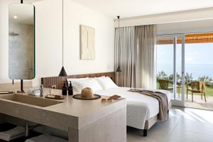 - une chambre avec un lit et une salle de bains pourvue d'un lavabo dans l'établissement Armacera Resort, à Zambrone