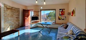 a living room with a couch and a table and a window at Luna Rossa in Castel di Tusa