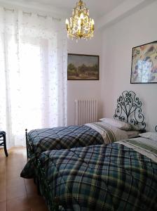 1 dormitorio con 2 camas y lámpara de araña en B&B Villa Diana, en Ancona