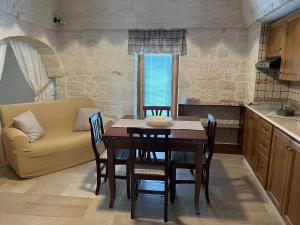 una cucina e una sala da pranzo con tavolo e divano di Cibum House ad Alberobello