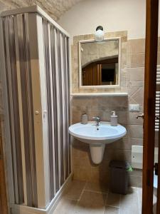 bagno con lavandino e specchio di Cibum House ad Alberobello