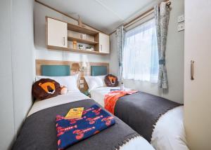 two beds in a small room with halloween pillows at Perran Heights Holiday Park in Perranzabuloe