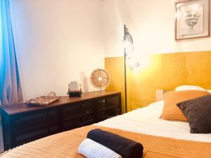 Schlafzimmer mit einem Bett und einem Schreibtisch mit einem Ventilator in der Unterkunft CASA AMARILLA Avec Exterieur in Nîmes