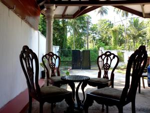 três cadeiras e uma mesa num pátio em Indra Sisila Villa Bentota em Bentota