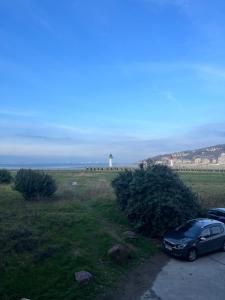 samochód zaparkowany obok pola z latarnią morską w obiekcie Mon balcon face à la mer - les Marinas Deauville w mieście Deauville