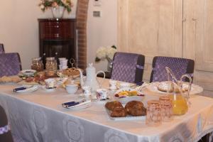 una mesa con un mantel blanco con comida. en B&B Podere di Sotto, en Montelupo Fiorentino