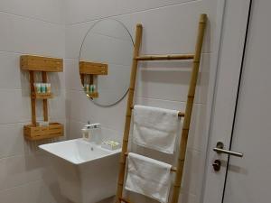 Baño blanco con lavabo y espejo en Релакс Хисаря 2 en Hisarya